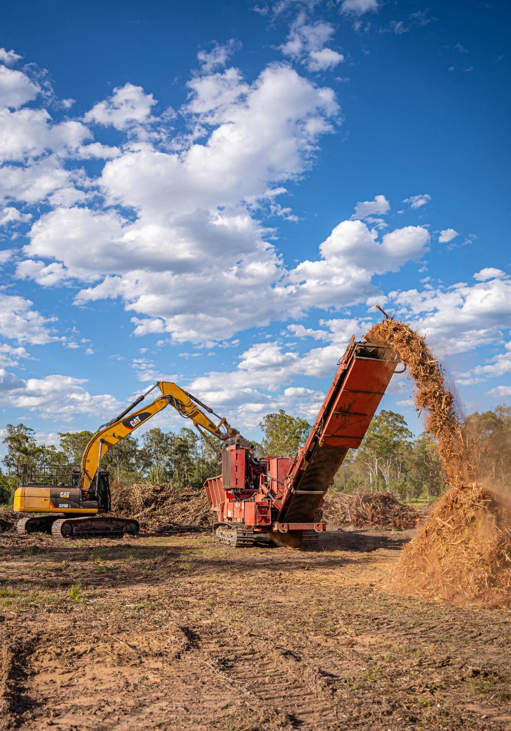 CAT dozer pushing soil beside a burn-off