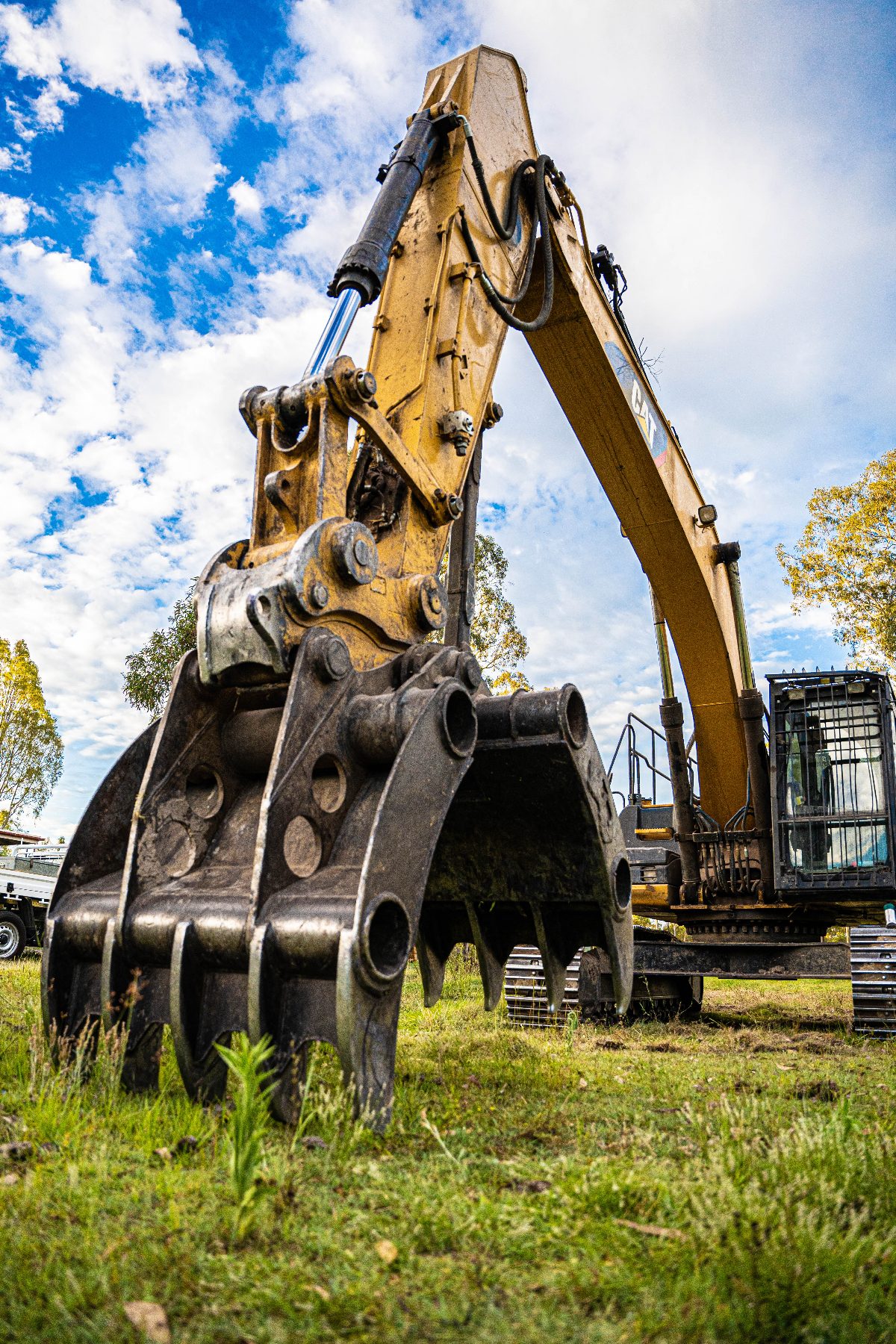 Close-up of an excavator grapple attachment on grass