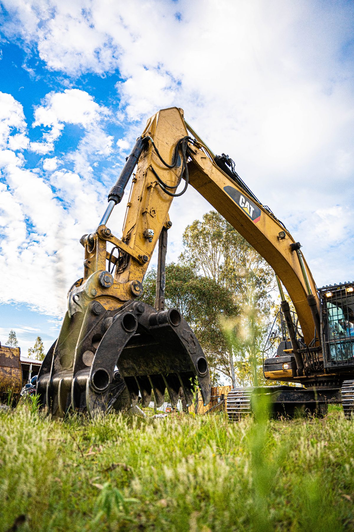 Low-angle view of a Tree Eaters excavator with grapple raised