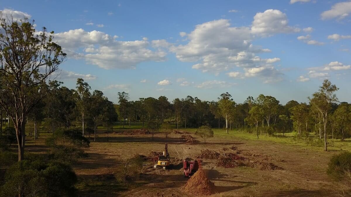 Aerial view of a Jimboomba block being cleared with an excavator and grinder working together