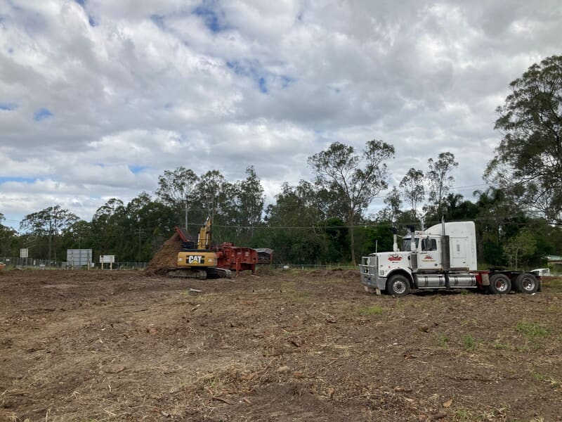 Mulch stockpiles across the finished Old Pub Lane block beside the road fence