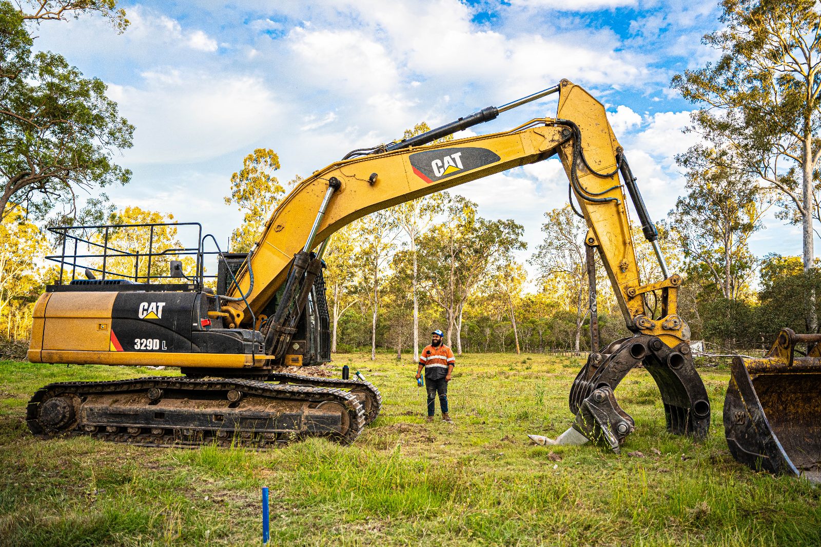 Tree Eaters operator beside the CAT 329D with grapple and bucket