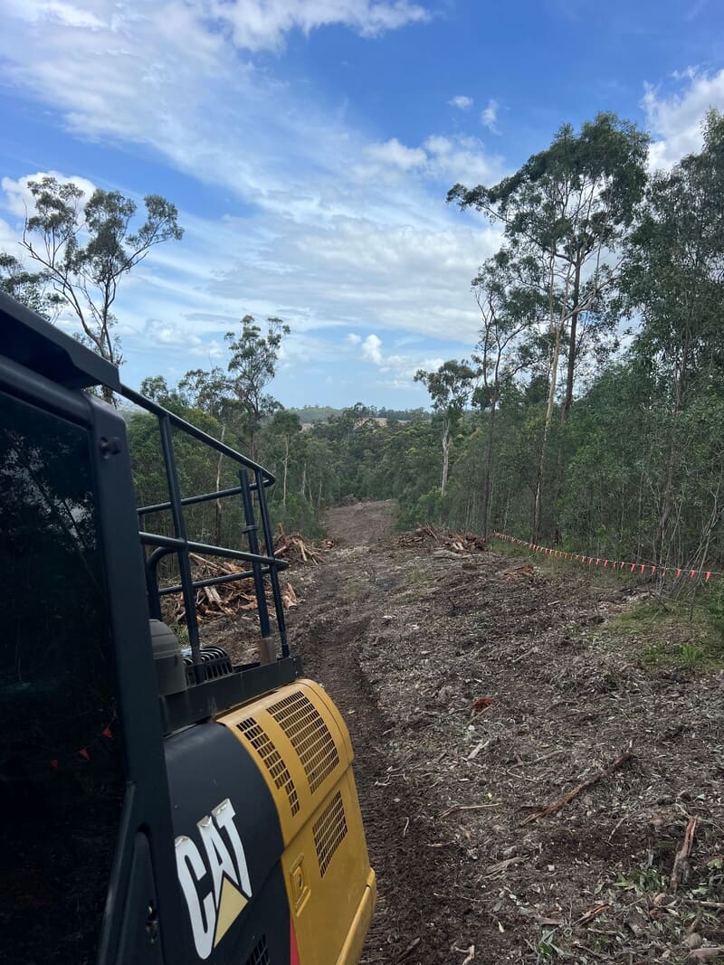Excavator at the start of the pipeline corridor with orange bunting marking the boundary