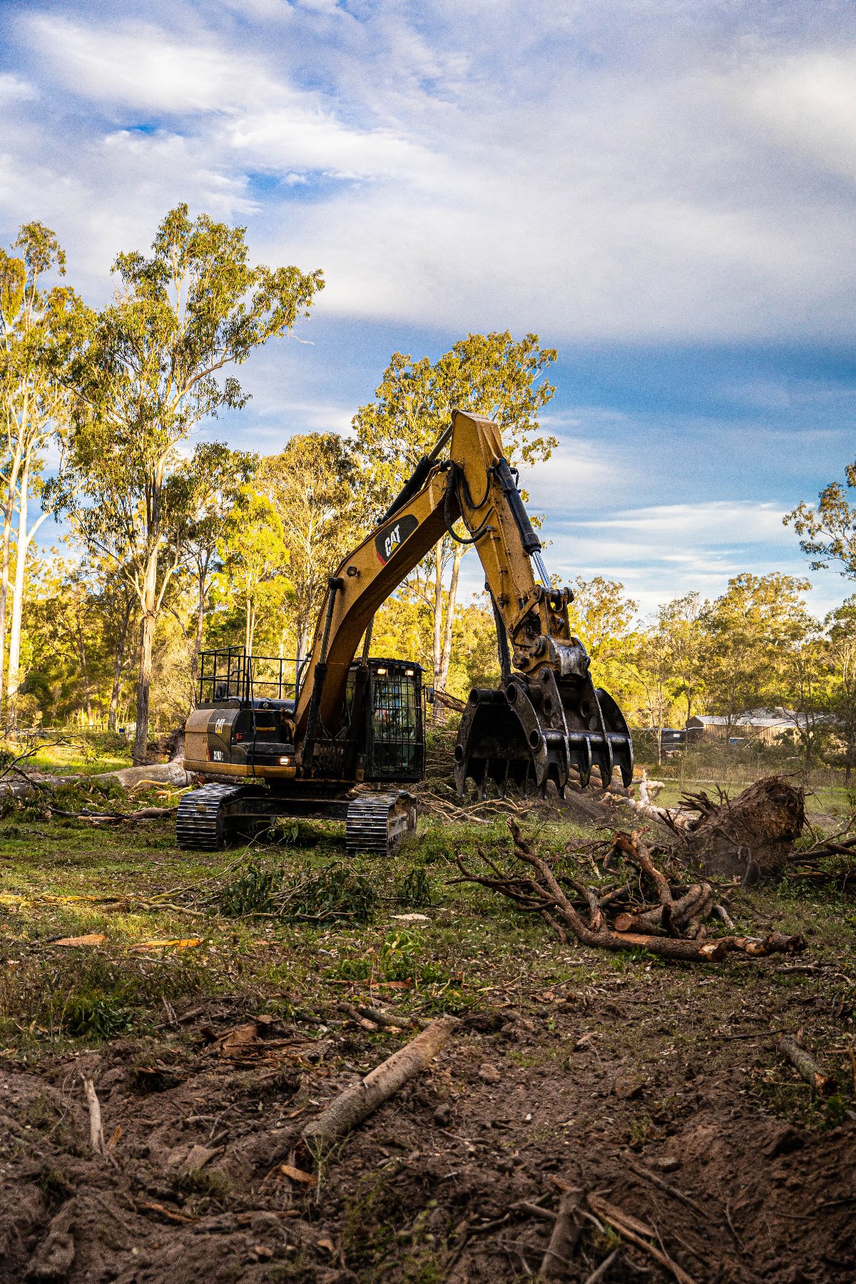 Excavator with stick rake on a cleared block