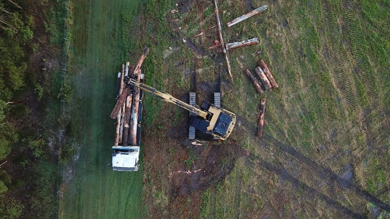 Aerial view of an excavator loading salvaged logs onto a truck at Stockleigh