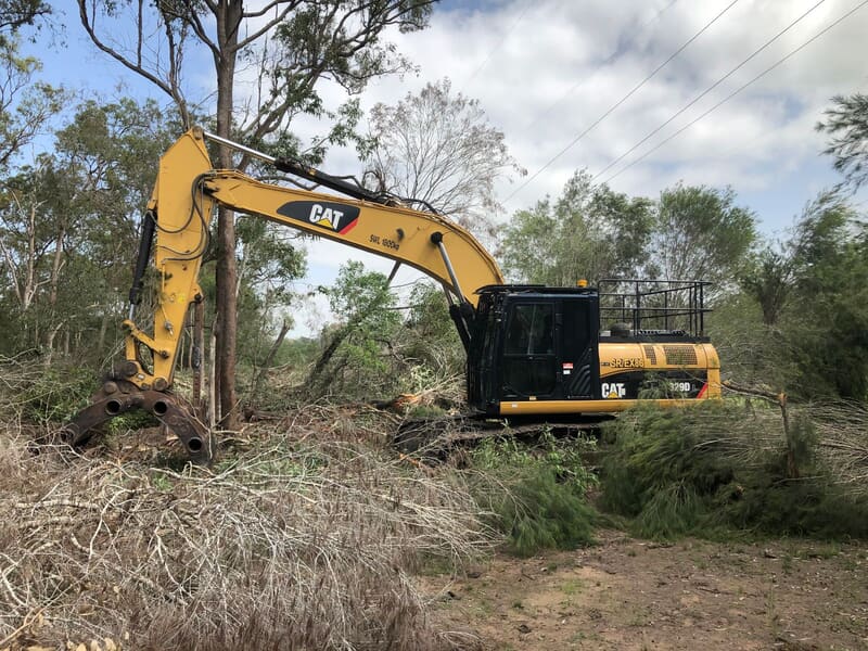 Grapple-equipped excavator clearing scrub beneath powerlines at Stockleigh Rd